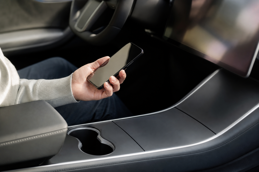 Tesla center console with a phone and key card in the cabin