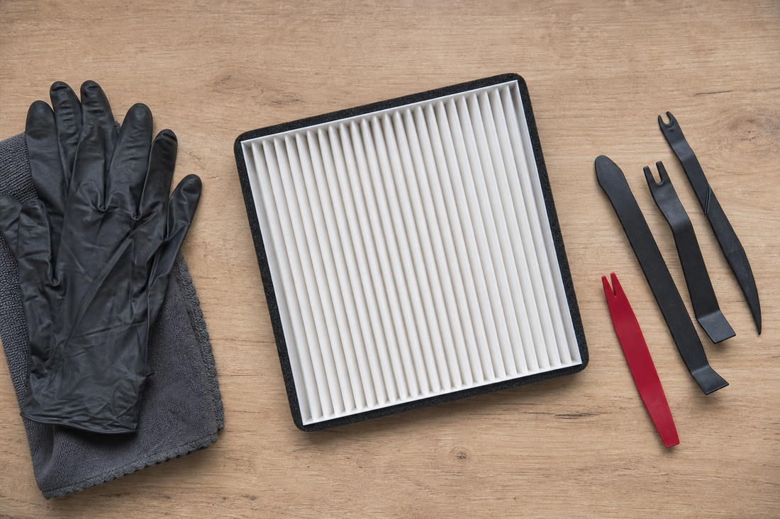 Tesla cabin air filter and trim tools on a clean workbench