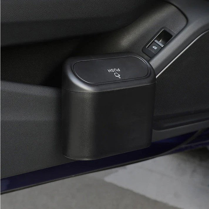 Compact black car trash can hanging from a Tesla door storage pocket